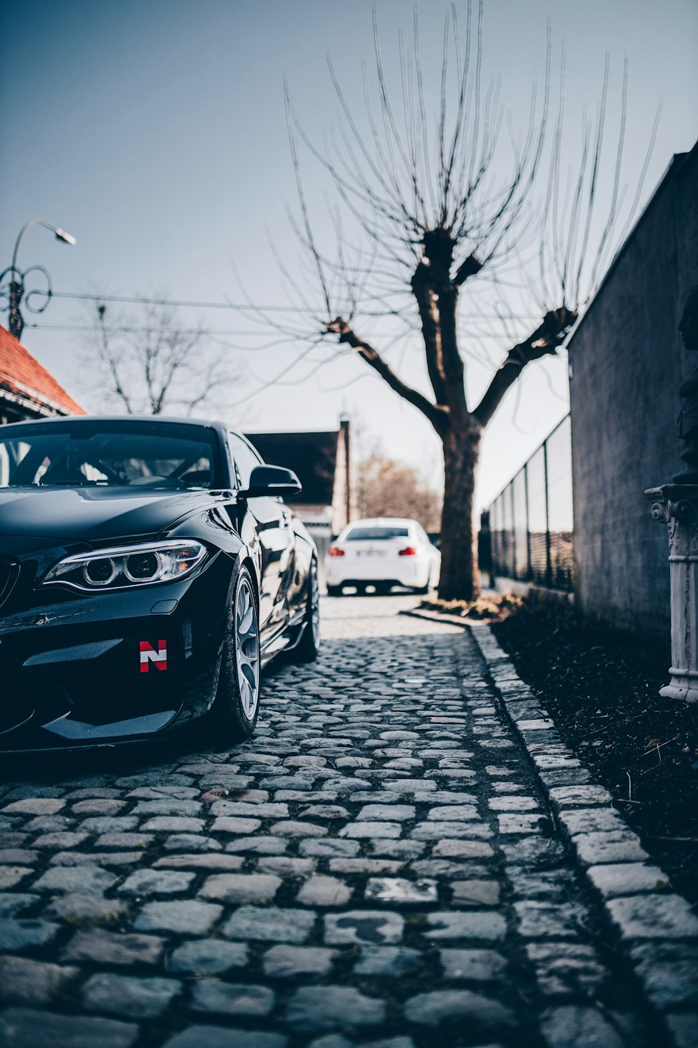 black porsche 911 parked on sidewalk during daytime