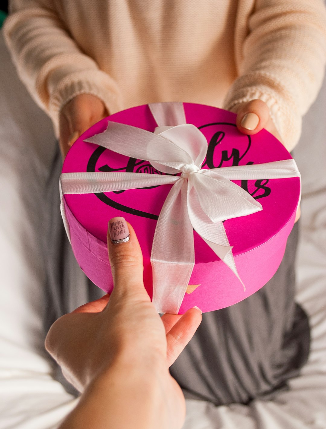 person holding pink and white heart paper