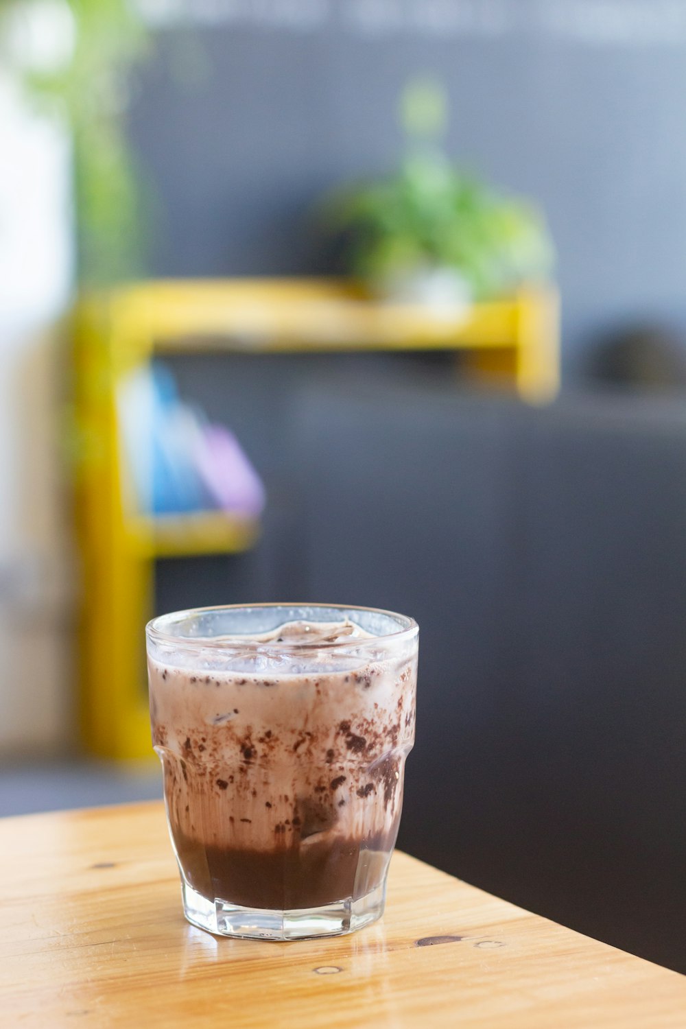 clear drinking glass with brown liquid on brown wooden table