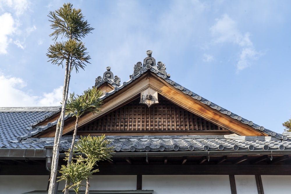 casa de madeira marrom e branca perto da palmeira sob o céu azul durante o dia