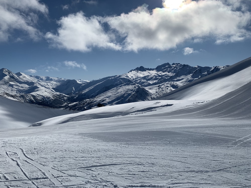 snow covered mountain under white clouds during daytime