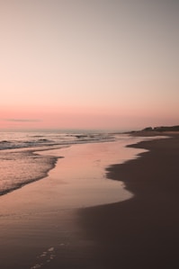 ocean waves crashing on shore during sunset