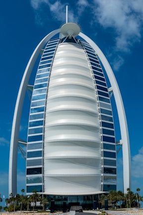 Street-level view of a sleek Binghatti tower against a bright blue sky.