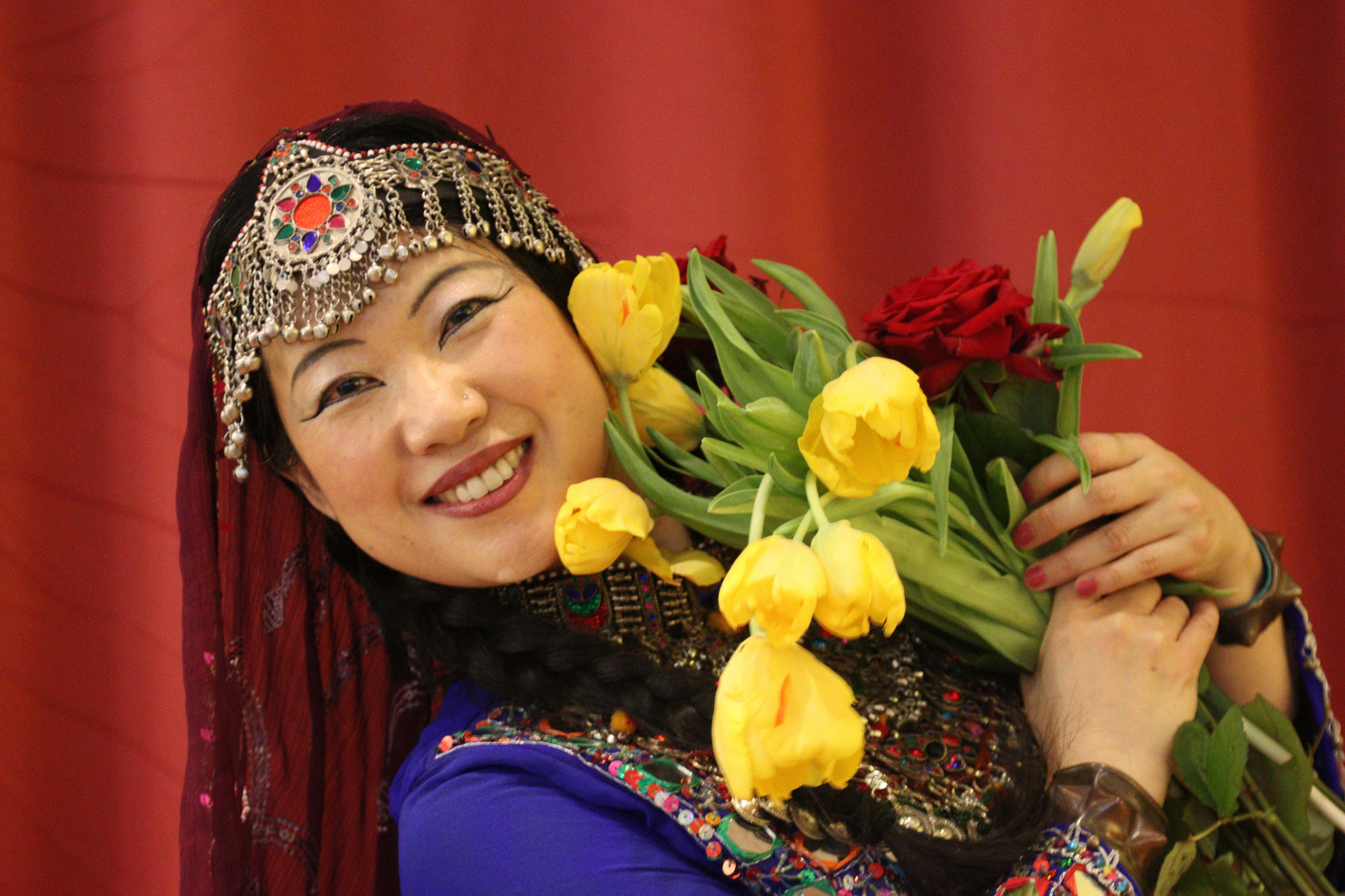 Beautiful Rwandan woman in traditional attire holding bouquet of flowers