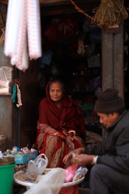 woman in red hijab sitting on the sidewalk in Bhaktapur Nepal