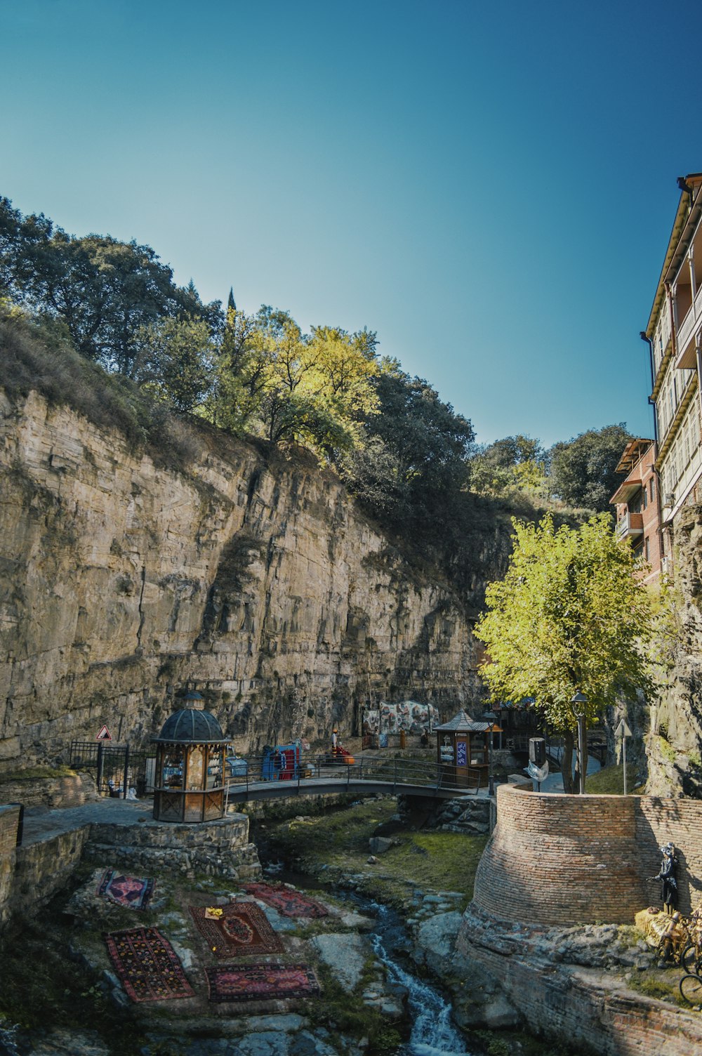 Braunes Betongebäude in der Nähe von grünen Bäumen und Bergen tagsüber