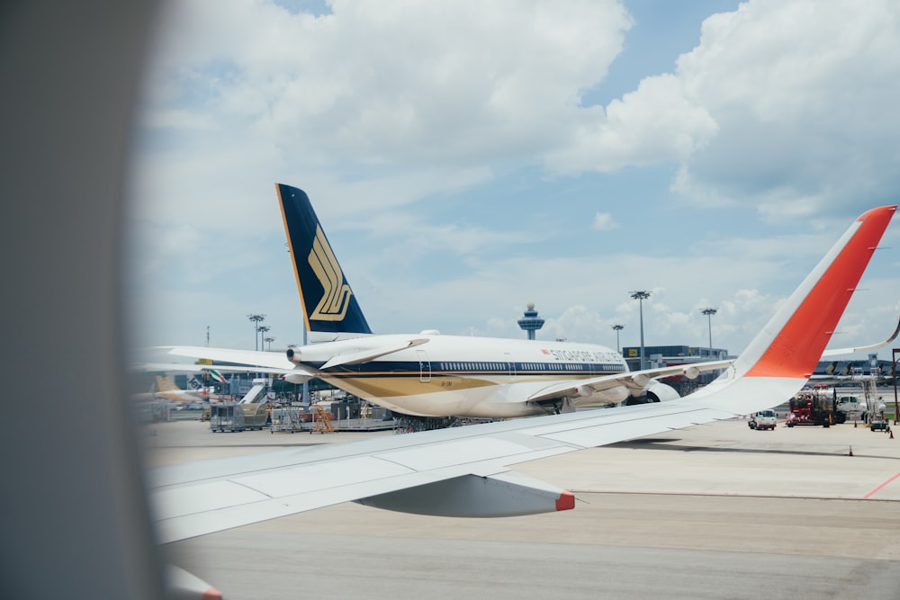 昼間の白い雲の下の白と青の飛行機