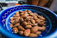 Fresh almonds and pistachios artfully arranged on a minimalist navy blue plate.