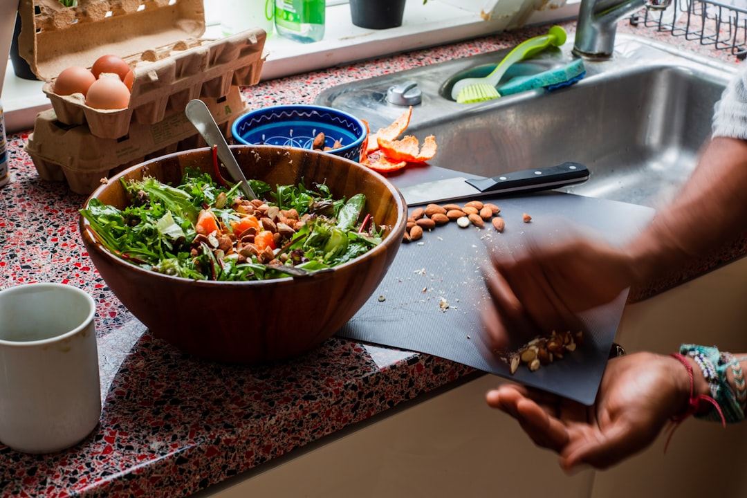 person slicing vegetable on chopping board