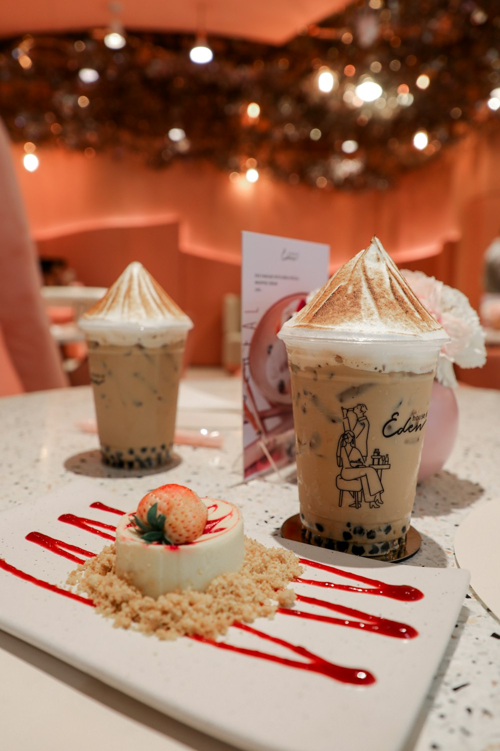 white and brown ceramic cup with strawberry and cream