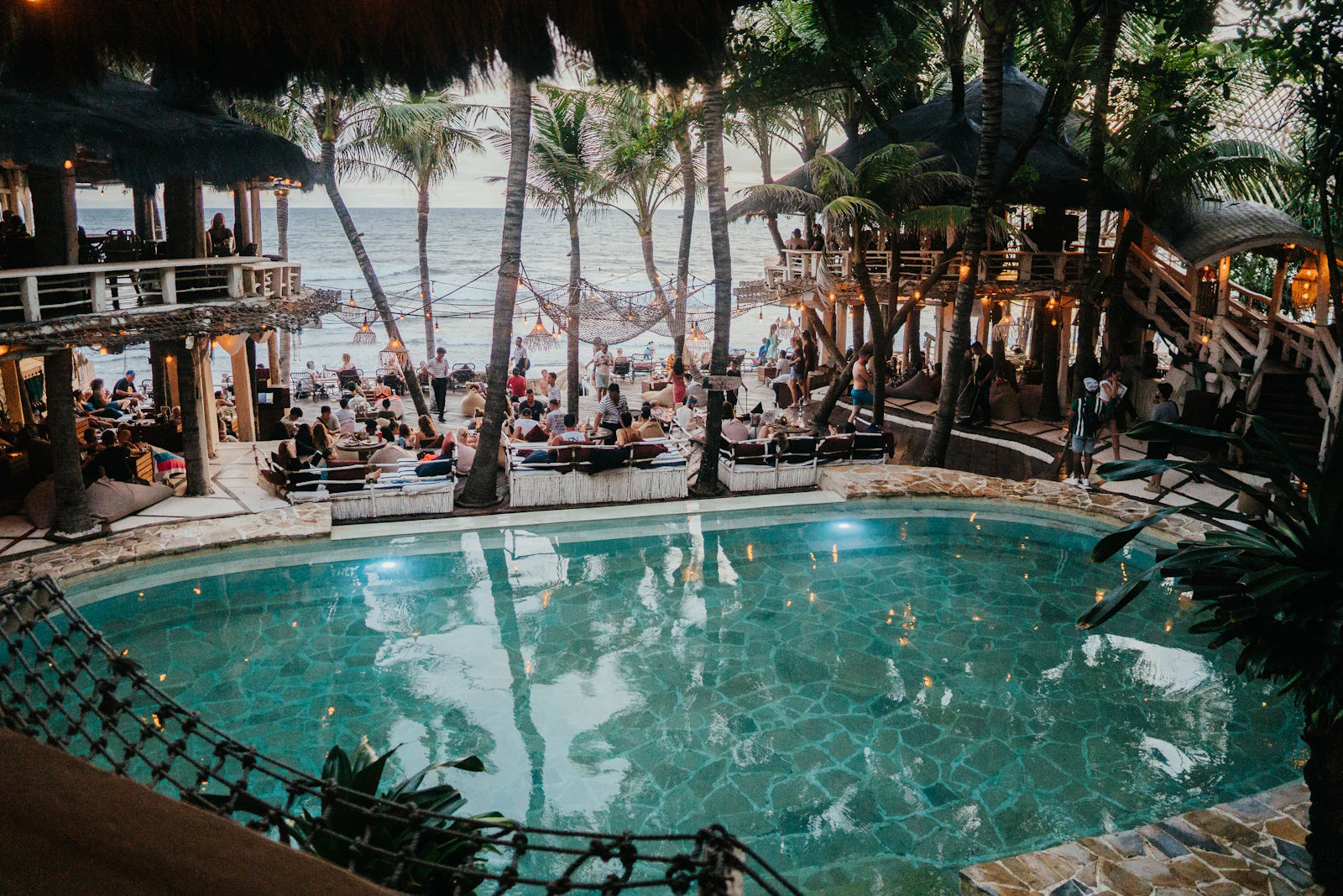 Aerial view of a beach club pool party with palm trees