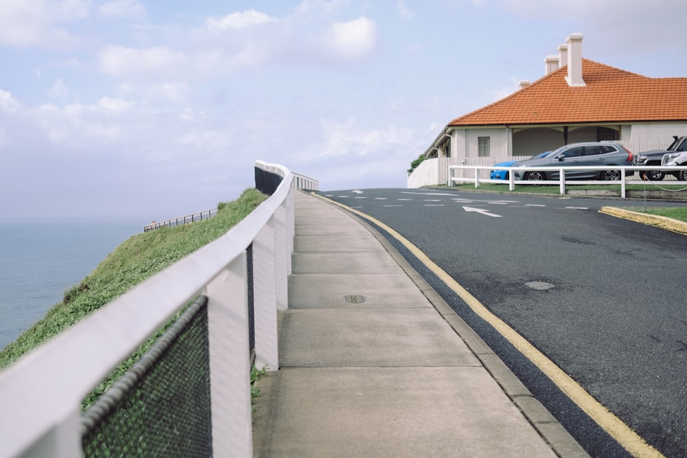 gray concrete road beside green grass field during daytime