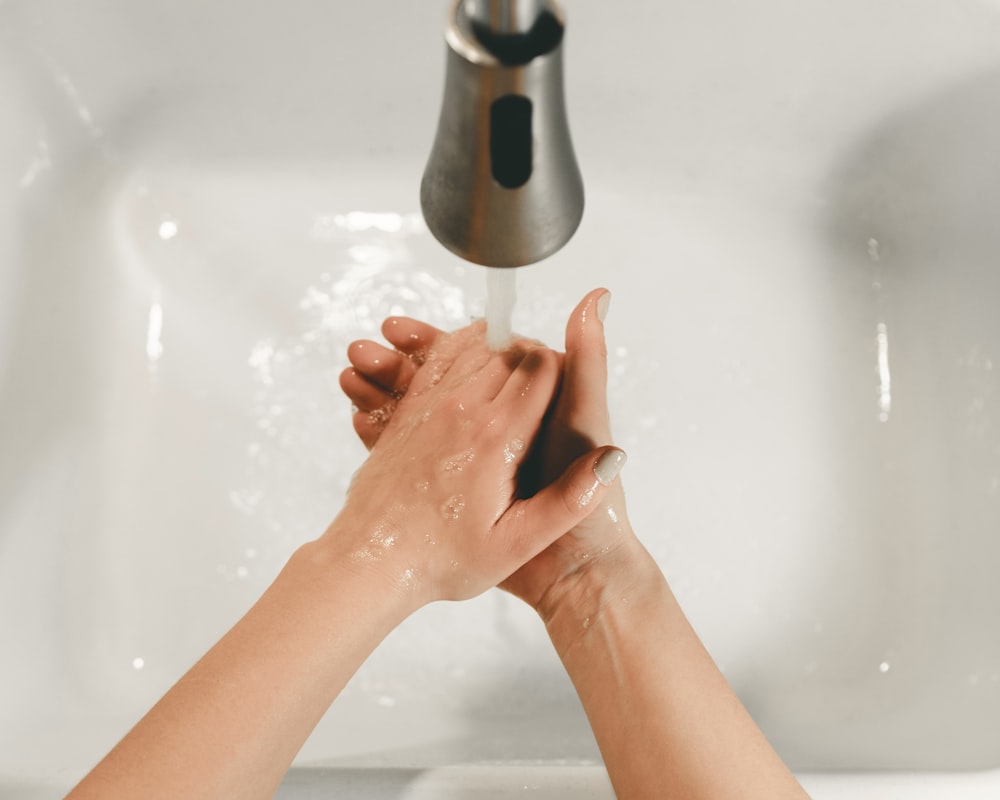 persons feet on white bathtub