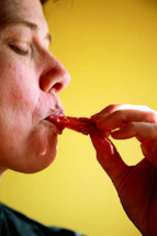person eating red food in yellow room