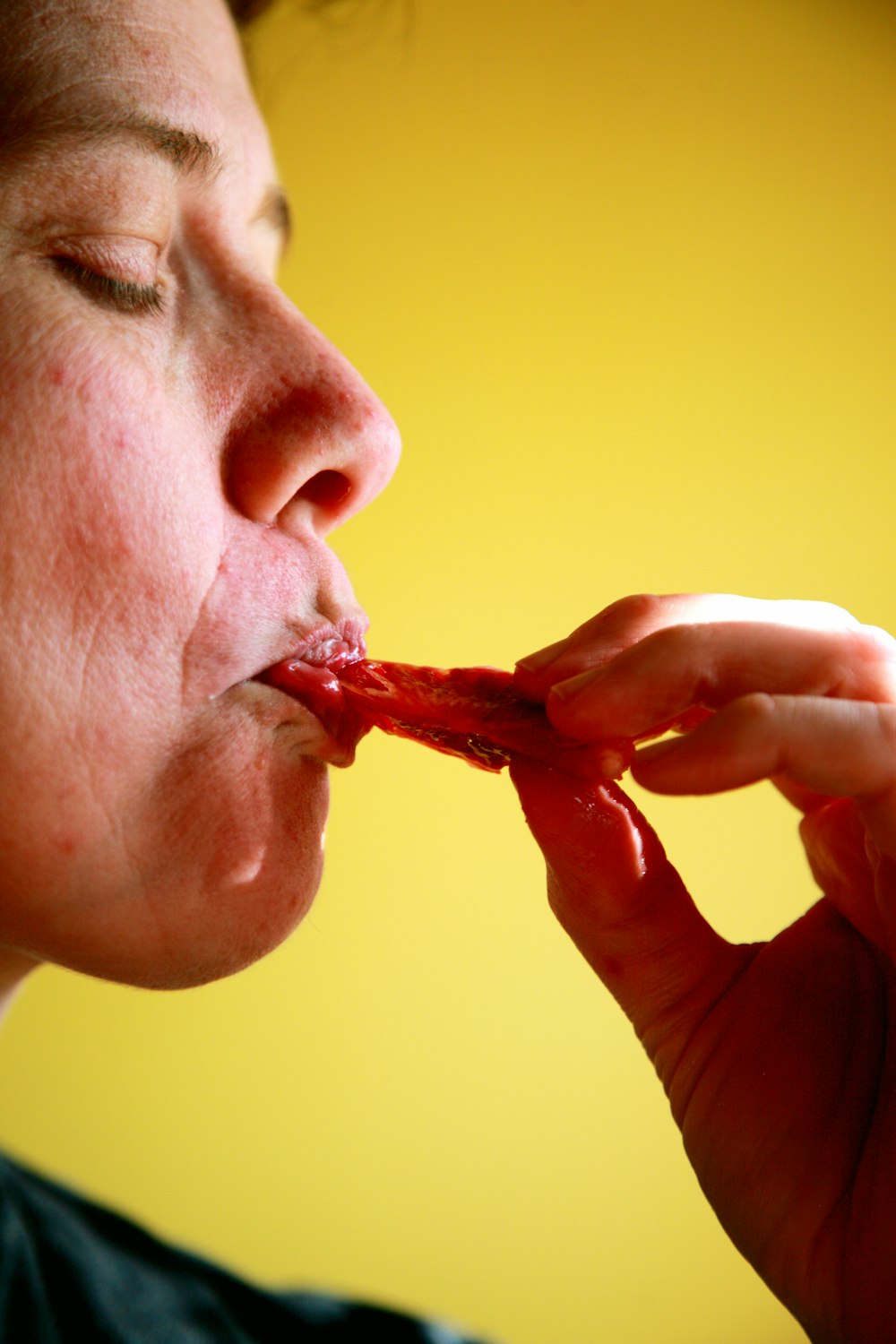 person eating red food in yellow room