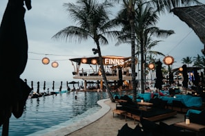people sitting on chairs near swimming pool during daytime