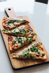 pizza with green leaf on brown wooden tray