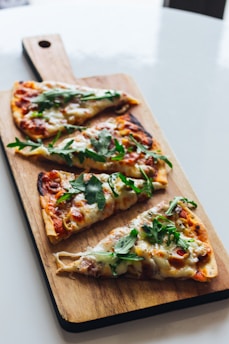 pizza with green leaf on brown wooden tray