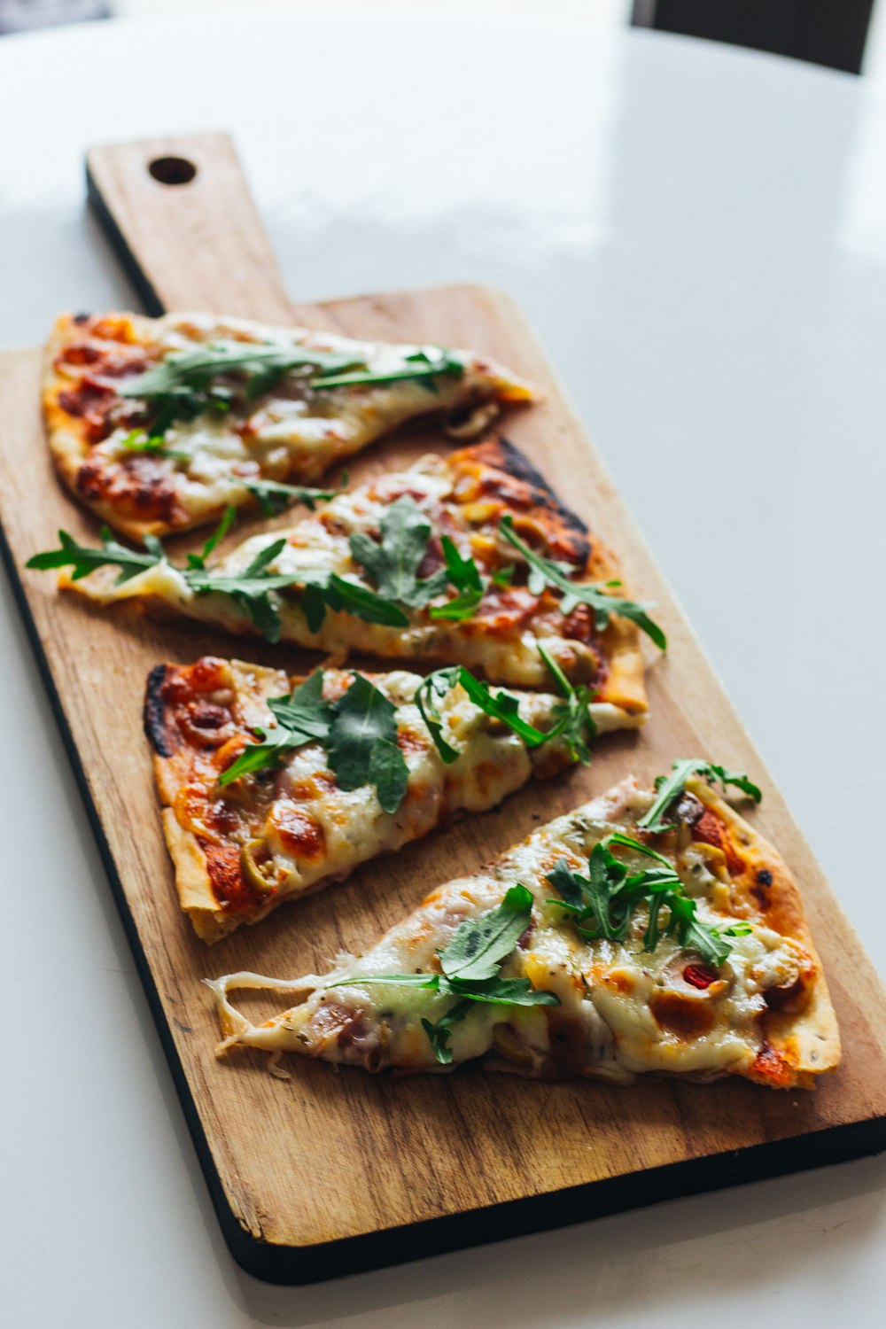 pizza with green leaf on brown wooden tray