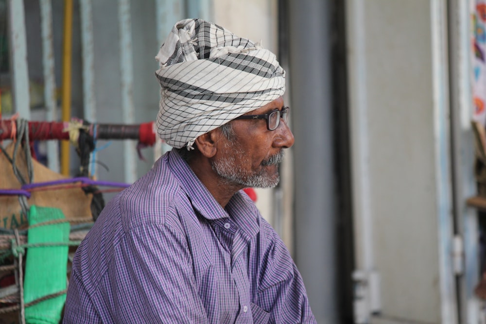 man in purple and white pinstripe dress shirt wearing white and black hat