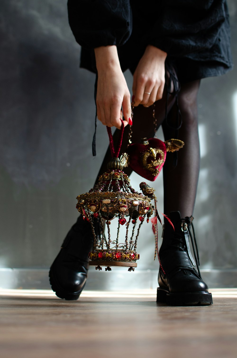 person in black leather boots holding gold trophy