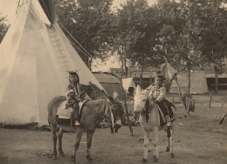 grayscale photo of people riding horses