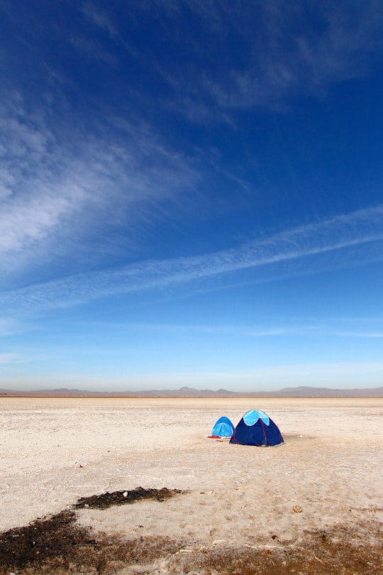 blue and white tent on brown sand under blue sky during daytime in Qom Iran