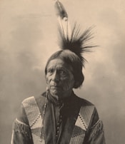 A serene portrait of an elder artist painting natural dyes onto bark cloth.