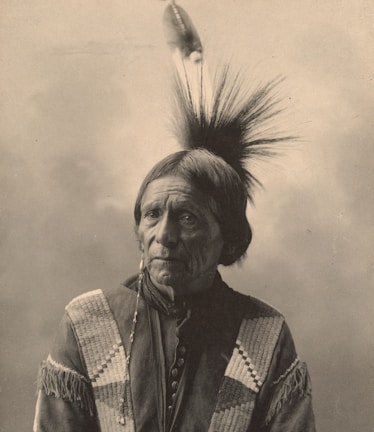 Portrait of a Native American elder sharing traditional wisdom in a sunlit room.