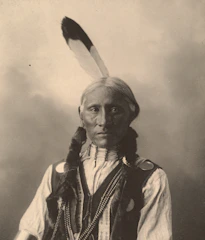 Close-up portrait of a tribal elder adorned with traditional jewelry and face paint