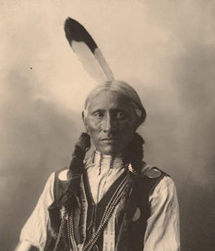 Close-up portrait of a tribal elder adorned with traditional jewelry and face paint