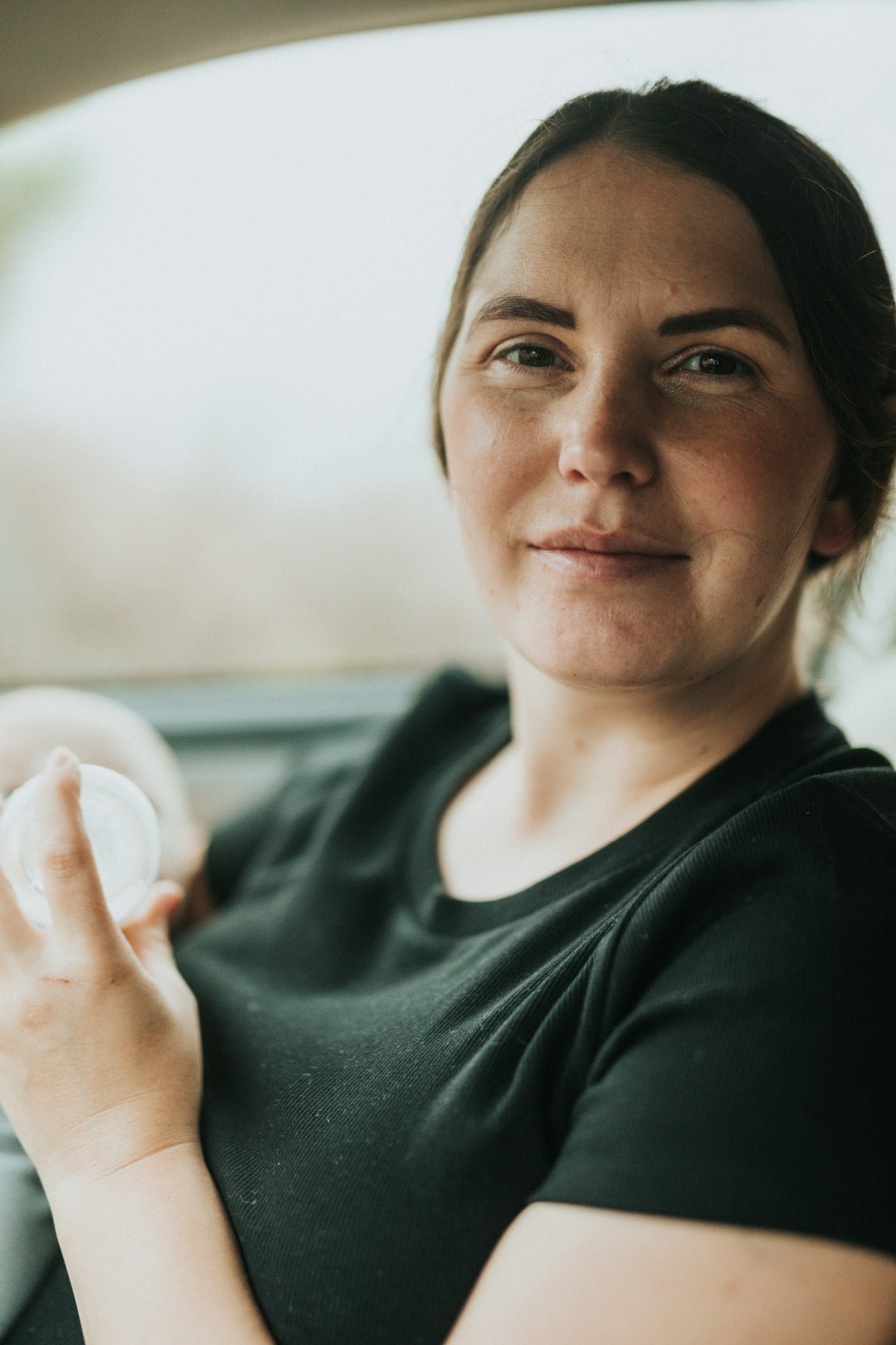 woman in black crew neck shirt holding white egg