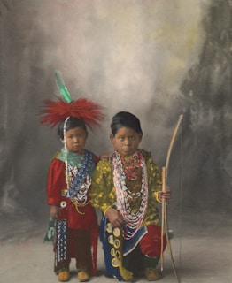 2 women in traditional dress holding stick