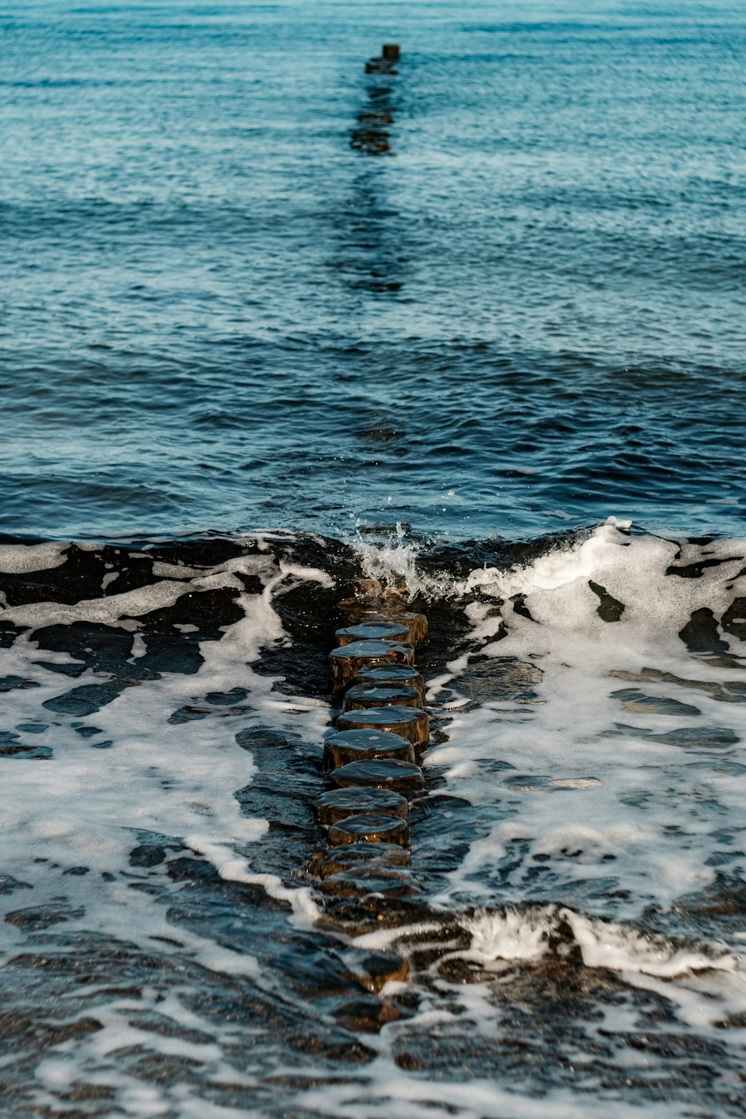 rocky shore with water waves during daytime