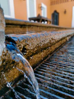 Close-up of flowing water in a small indoor fountain surrounded by smooth stones.