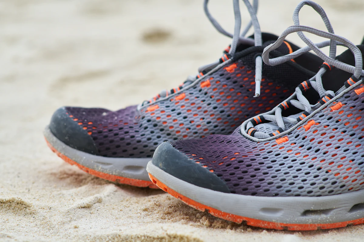 Schwarz-weißer Laufschuh auf braunem Sand