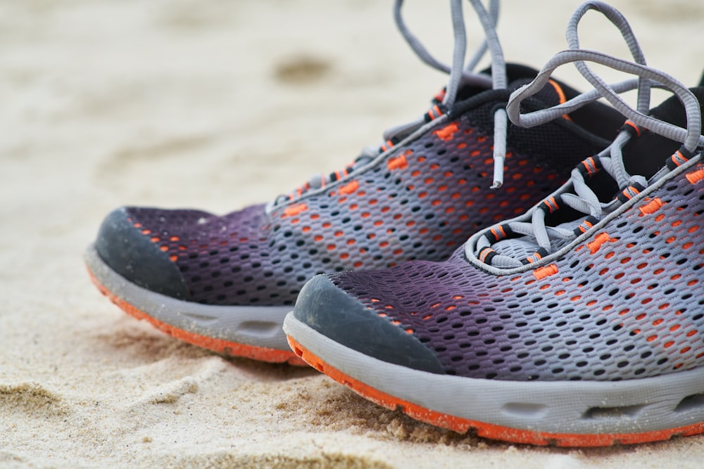 black and white nike athletic shoe on brown sand