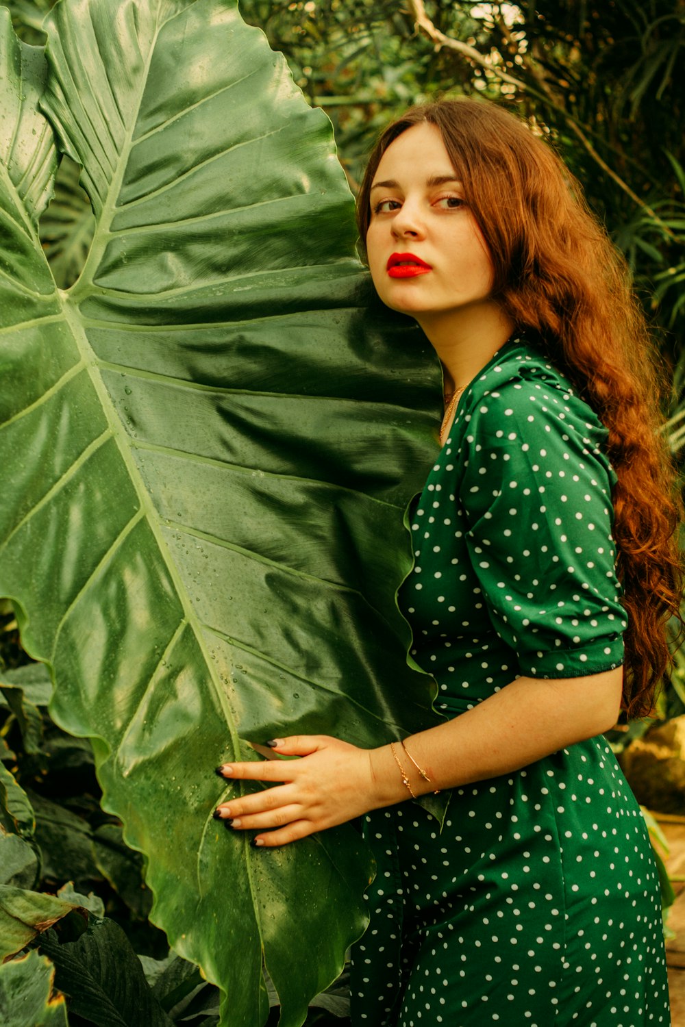 woman in green long sleeve shirt lying on green grass field