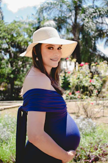 A model wearing a fashionable hat in a sunny outdoor setting.