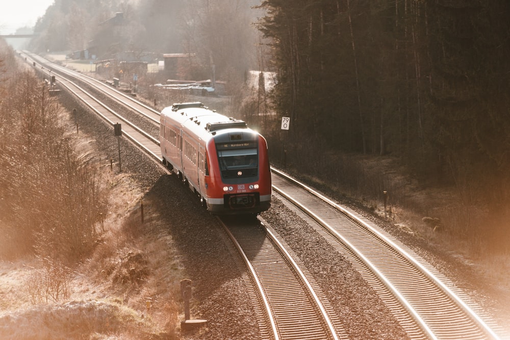 trem vermelho e branco na estrada de ferro durante o dia