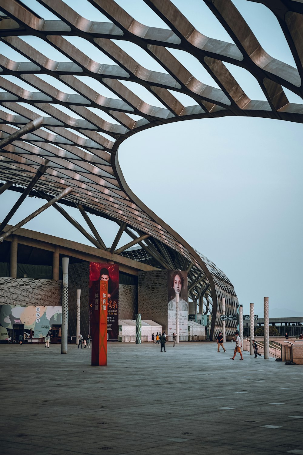 people walking on gray concrete pathway under gray sky during daytime