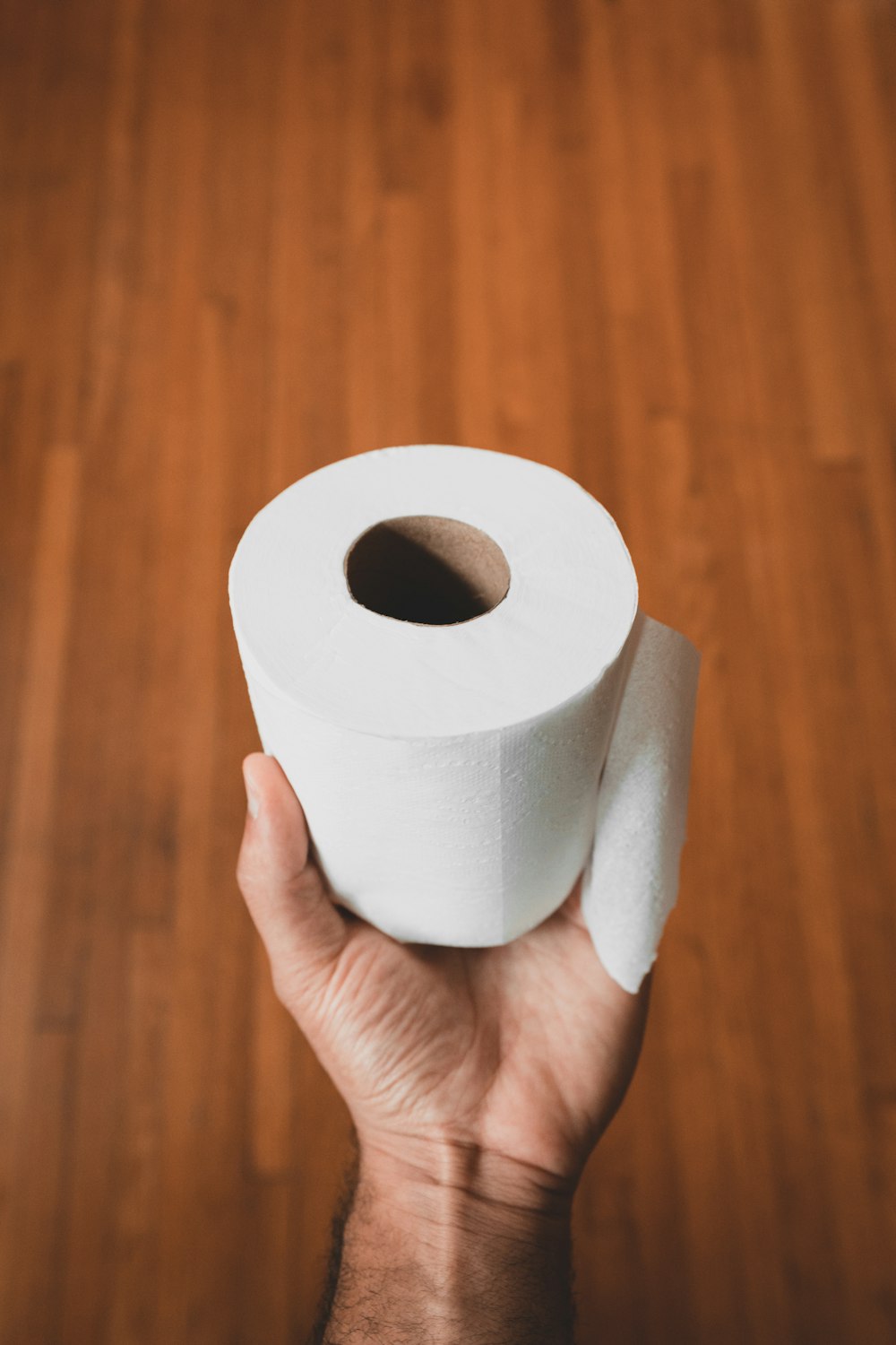 Person mit weißer Toilettenpapierrolle