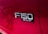 A close-up view of a red vehicle's side panel with the badge 'F-150 XLT' prominently displayed in chrome letters against a black background.