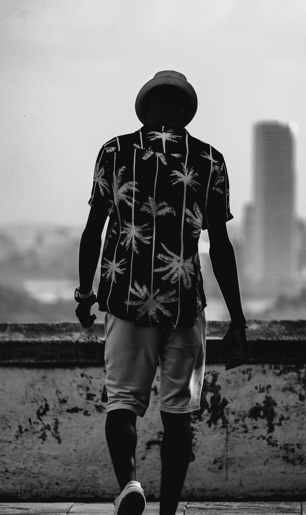 grayscale photo of man in black and white star print long sleeve shirt and white pants