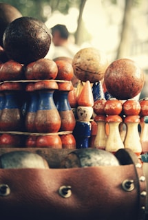 A collection of vintage and modern balls lined up on a rustic wooden bench.