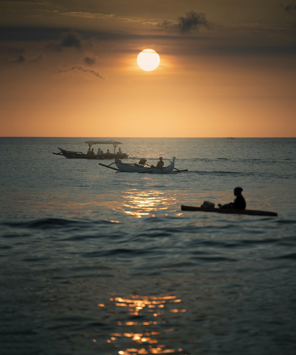 Silhouette de 2 personnes chevauchant sur un bateau au coucher du soleil