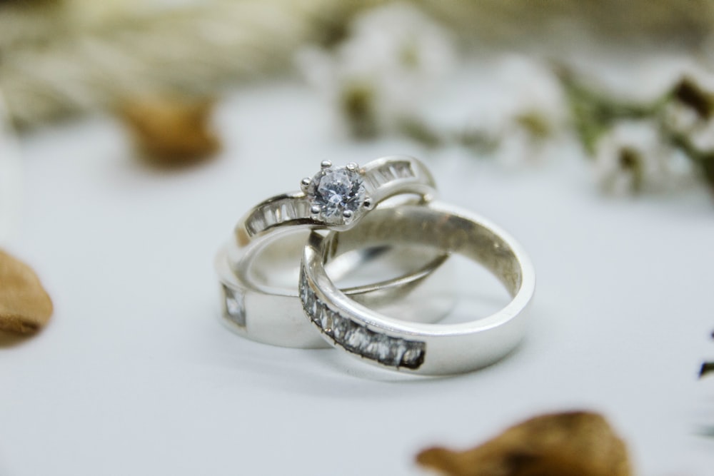 bague en argent et diamant sur surface blanche