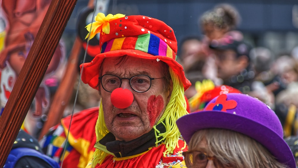 uomo in camicia gialla, blu e rossa che indossa un cappello giallo e rosso