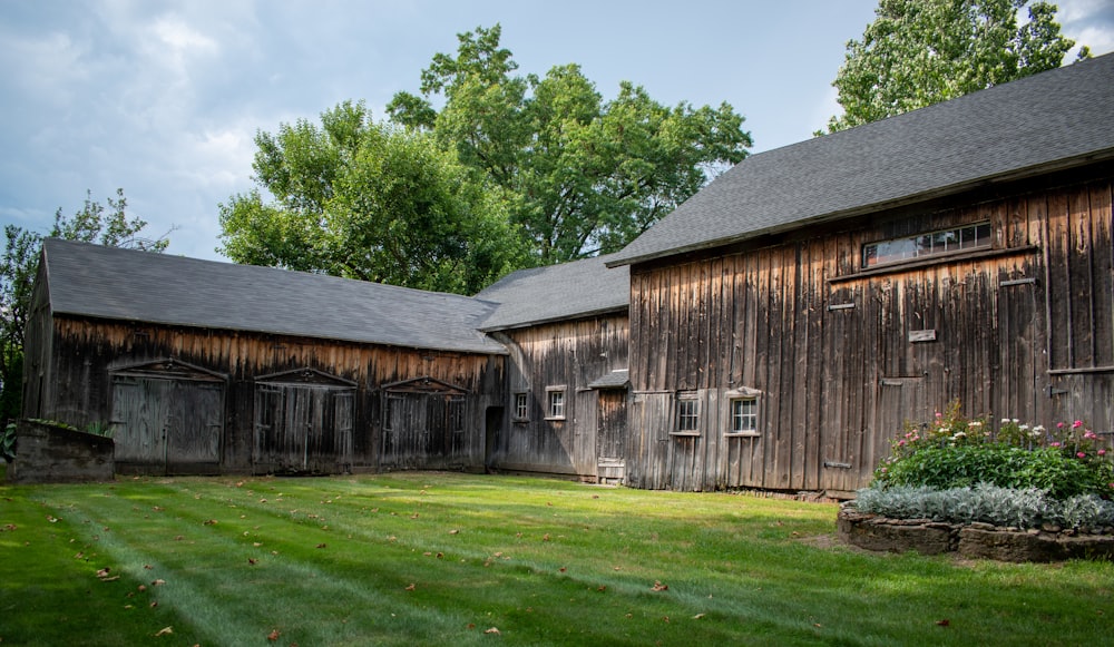 Braunes Holzhaus in der Nähe von grünen Bäumen tagsüber