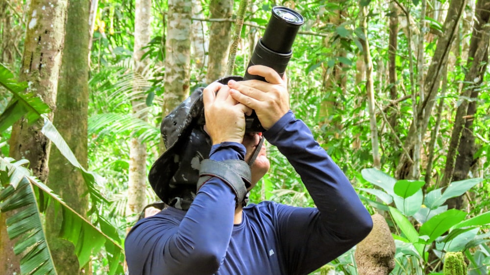 man in black jacket holding black dslr camera